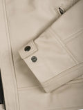 Close-up of beige leather jacket sleeve and button cuff