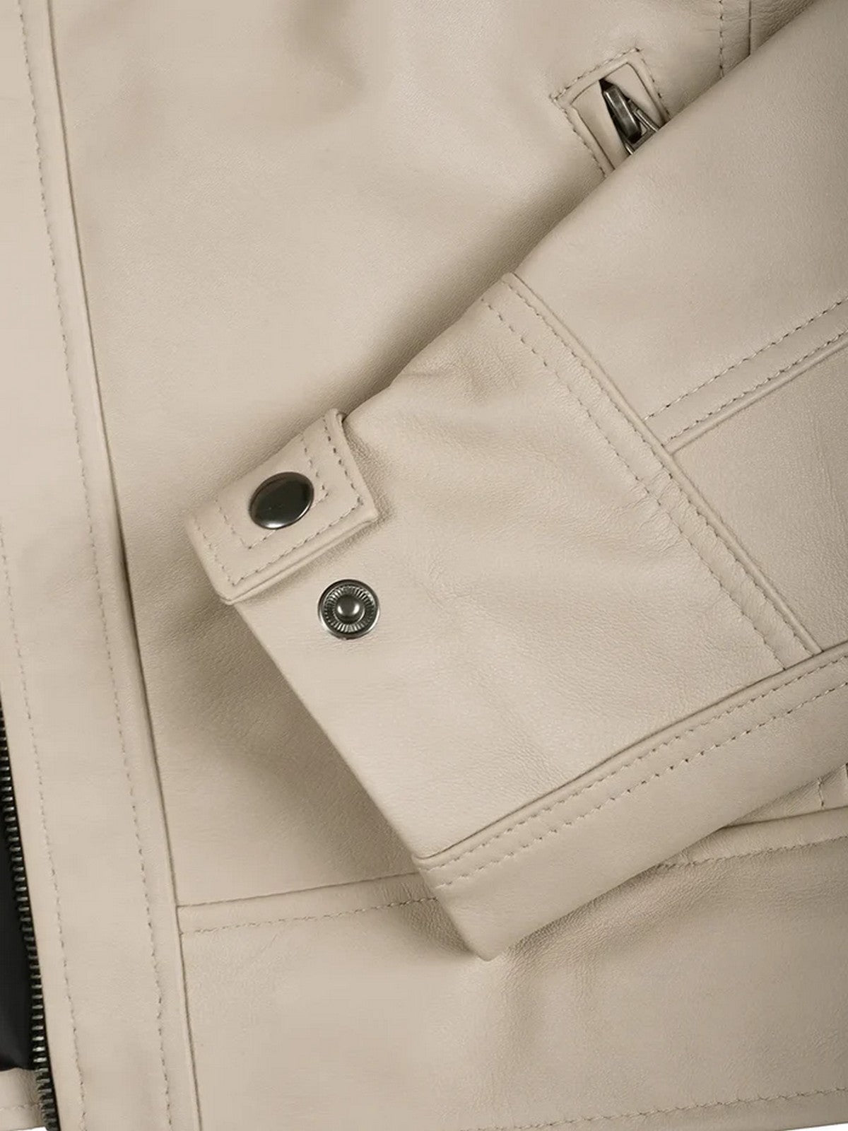 Close-up of beige leather jacket sleeve and button cuff